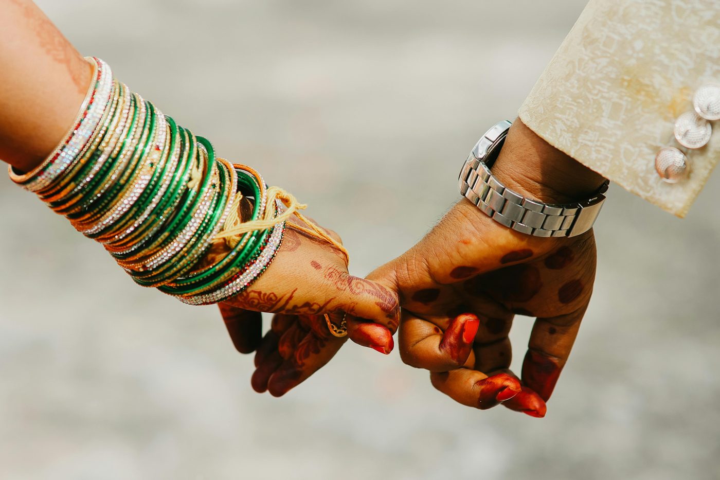 Hands with bangles and mehndi held together